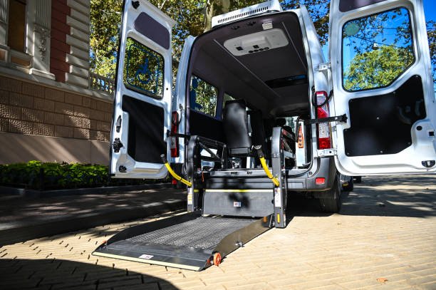 A white van featuring a side ramp, marked with NEMT Solutions, intended for non-emergency medical transport.