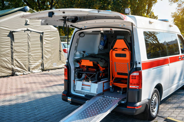 A wheelchair is parked beside an ambulance, indicating non-emergency medical transportation services available.
