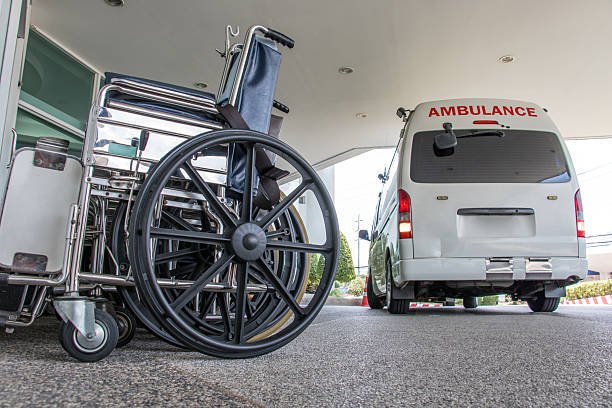A wheelchair is positioned next to an ambulance, symbolizing access to non-emergency medical transportation options.