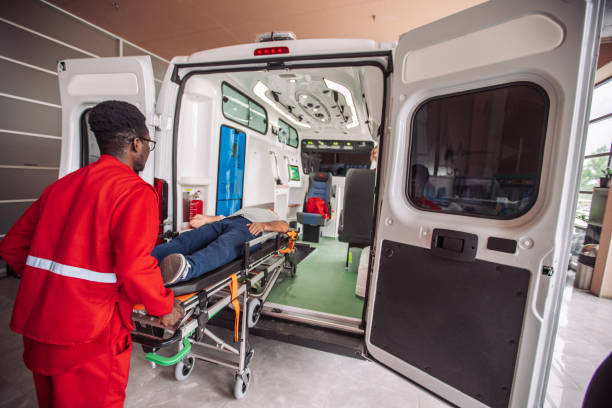 Paramedics from Private Ambulatory Services are lifting a man into an ambulance for transport.

